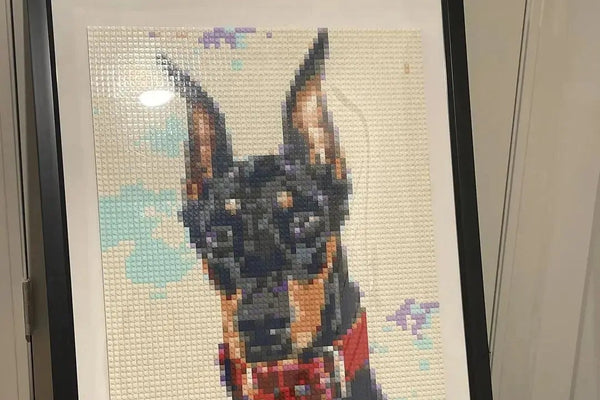 A finished brick mosaic of a Doberman in a black frame at home